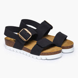 A pair of Condor Platform sandals angled to reveal the deep anatomical heel cups and the impressive craftsmanship of the contoured cork midsole. The dual adjustable black straps feature polished metallic buckles, resting atop a plush tan suede lining that embodies the "Nature’s Hug" philosophy—where bold, modern lines meet the raw purity of the earth.