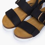 Looking directly down into the Condor footbeds, where the biologically contoured cork follows the natural shape of the foot. The deep black nubuck straps frame the "Plakton Memory Cushion" branding at the heel, illustrating a design that supports skeletal alignment through the use of renewable, earth-born materials.