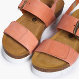 Looking directly down into the Condor footbeds, where the biologically contoured cork mimics the foot's natural impression. The soft peach nubuck straps frame the "Plakton Memory Cushion" branding, illustrating a design that prioritizes skeletal alignment and comfort through the use of renewable, earth-born materials.
