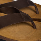 A detailed close-up of the handmade brown nobuck leather straps and the fine grain of the sustainable Spanish cork, emphasizing the artisanal quality and premium materials of the Plakton sandal.