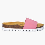 A side-profile view of the Barcadi Flat in Pink - Handmade by Plakton. A soft pink elastic strap arches over the footbed, anchored to a beautifully contoured midsole of sustainable Spanish cork. The design is finished with a crisp, white serrated outsole, blending organic warmth with a fresh, modern energy.
