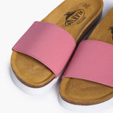 An overhead perspective of the Barcadi's vibrant pink straps and velvety tan suede-lined cork footbeds. The image highlights the natural textures of the materials, illustrating a design inspired by the sea and perfected for a life lived in effortless flow.