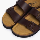 An overhead view of the Barna sandals, focusing on the textured Dakota leather and the expansive, suede-lined cork base. The embossed "Memory Cushion" signature is visible, emphasizing the plush, foam-infused layer that provides immediate comfort without the need for a break-in period.