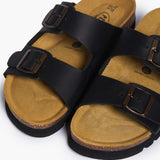 An overhead view looking directly into the Beta footbeds. The image captures the natural width of the cork base and the prominent "Plakton Memory Cushion" branding at the heel. The buckled Soft Black straps frame the hand-sculpted contours, illustrating a design that honors the foot’s natural shape and movement.