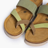 An overhead view looking directly into the Bloom footbeds. The image captures the natural width of the cork base and the prominent "Plakton Memory Cushion" branding at the heel. The overlapping green suede straps frame the hand-sculpted contours, illustrating a design built for anatomical support.
