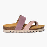 A side profile of the Bloom flat sandal, highlighting the slim, sustainable Spanish cork midsole. Overlapping suede straps in varying shades of pink create a soft, layered look against the organic cork grain, all resting on a durable flat outsole for a grounded, natural feel.