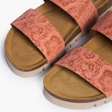 Close-up overhead shot of the Plakton Brynn sandal toe area, highlighting the intricate floral laser-cut patterns on the micro-suede straps and the soft suede-lined cork footbed.