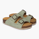 A pair of CP Beta sandals in Mint Studded Suede, angled to show the deep, anatomical heel cups carved from renewable cork oak. The dual adjustable straps, embellished with silver-tone studs and buckles, rest atop a plush tan suede lining, embodying the "Nature’s Hug" philosophy through a blend of raw cork and refined hardware.