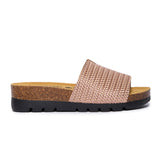 A salmon-colored sandal with a woven upper and a cork-like sole, handmade in Spain.