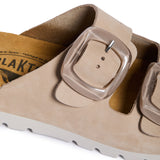 Close-up of a sandal with a buckle detail on a white background